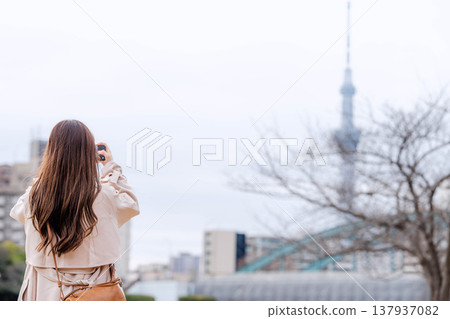 一位年輕女子在東京晴空塔附近觀光。 一位年輕女子在東京晴空塔附近觀光。 137937082