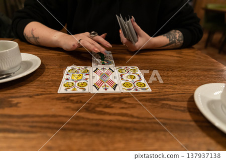 Tarot cards and fortune telling. Soothsayer predicting future with tarot cards. Unrecognizable mysterious fortuneteller holding tarot cards forecasting future for client. Future reading esoteric Tarot cards and fortune telling. Soothsayer predicting future with tarot cards. Unrecognizable mysterious fortuneteller holding tarot cards forecasting future for client. Future reading esoteric 137937138