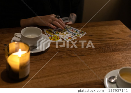 Tarot cards and fortune telling. Soothsayer predicting future with tarot cards. Unrecognizable mysterious fortuneteller holding tarot cards forecasting future for client. Future reading esoteric Tarot cards and fortune telling. Soothsayer predicting future with tarot cards. Unrecognizable mysterious fortuneteller holding tarot cards forecasting future for client. Future reading esoteric 137937141
