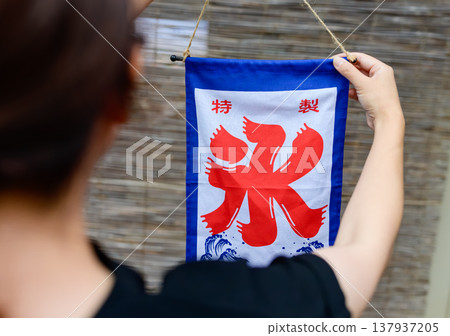 一面特製的刨冰旗幟懸掛在竹屏風背景前。 137937205