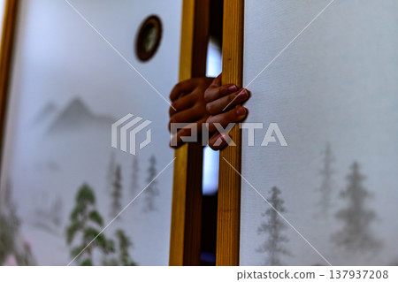 A child's hand peeking through a gap in the sliding door A child's hand peeking through a gap in the sliding door 137937208