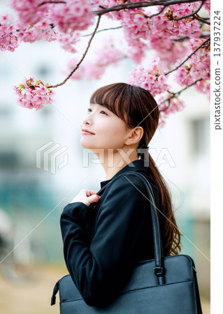 Young woman with cherry blossoms in the background 137937224