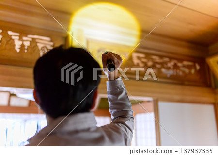 一名工人用手電筒照射傳統日式建築的天花板。 137937335