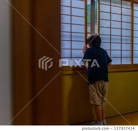 孩子從背後透過障子門向外窺視。 137937414
