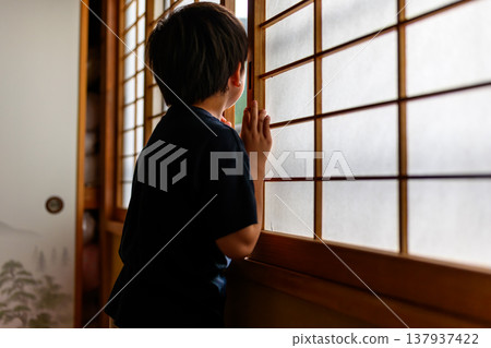 孩子從背後透過障子門向外窺視。 137937422