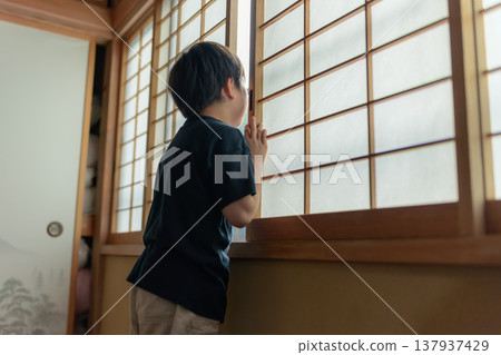 一個男孩打開障子門，向外窺視。 137937429