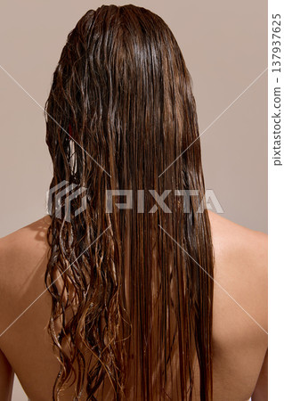 Back view of wet curly hair showing treatment result in studio. 137937625