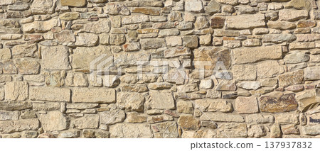 Rough stone wall texture creating rustic background pattern Rough stone wall texture creating rustic background pattern 137937832