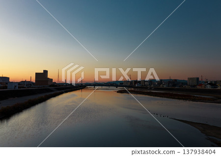 黃昏時分,河流和城市景觀的輪廓清晰可見。 黃昏時分,河流和城市景觀的輪廓清晰可見。 137938404