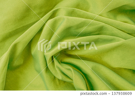 Vibrant lime green cotton texture with heavy organic folds. The dense, denim-like fabric features a visible twill weave and deep shadows, creating an energetic background Vibrant lime green cotton texture with heavy organic folds. The dense, denim-like fabric features a visible twill weave and deep shadows, creating an energetic background 137938609