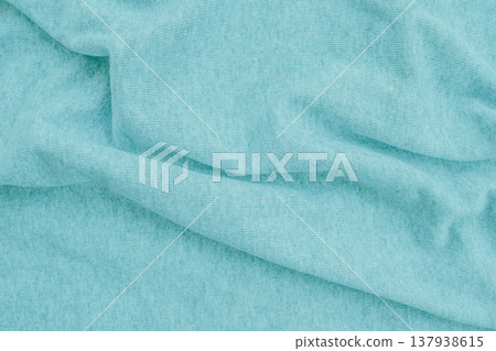 Soft turquoise cotton fabric with gentle organic waves. The mint-colored textile features a matte knit texture and natural shadows, creating a calm, versatile background Soft turquoise cotton fabric with gentle organic waves. The mint-colored textile features a matte knit texture and natural shadows, creating a calm, versatile background 137938615