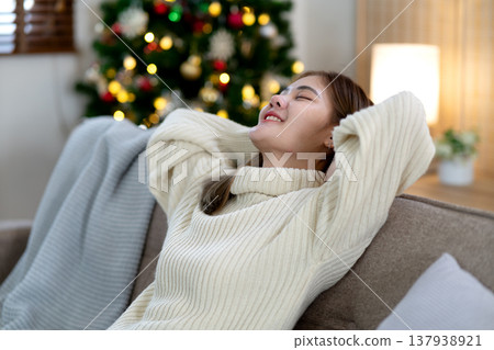 young woman leaning on the sofa half asleep and smiling young woman leaning on the sofa half asleep and smiling 137938921