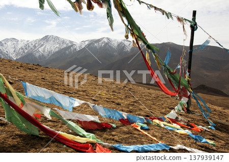 青海拉傑山上空飄揚著藏式經幡，遠方是白雪皚皚的山巒景色。 137939147