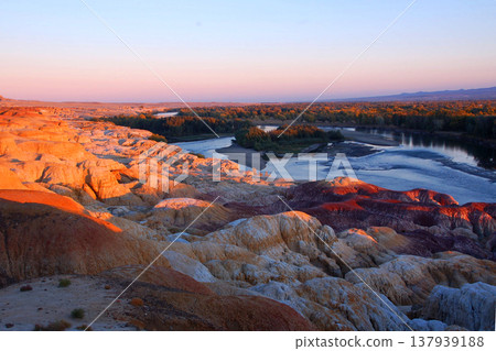 The light of the sunset shines on the Yardang landscape of Xinjiang's Five-Colored Beach. The light of the sunset shines on the Yardang landscape of Xinjiang's Five-Colored Beach. 137939188