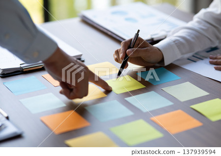 close shot businessman pointing finger at sticky note on table 137939594