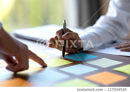 close shot businessman pointing finger at sticky note on table close shot businessman pointing finger at sticky note on table 137939595
