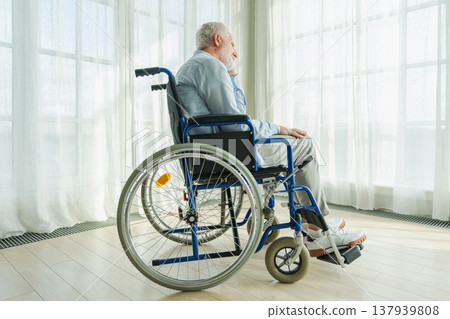 Sad senior man sitting in wheelchair looking out window in retirement home hospital. Old paralyzed man in chair for people with disability feel depressed. Lonely elderly sick man sitting on wheelchair Sad senior man sitting in wheelchair looking out window in retirement home hospital. Old paralyzed man in chair for people with disability feel depressed. Lonely elderly sick man sitting on wheelchair 137939808