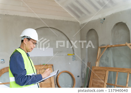 Construction supervisors are reviewing and writing checklists Construction supervisors are reviewing and writing checklists 137940040