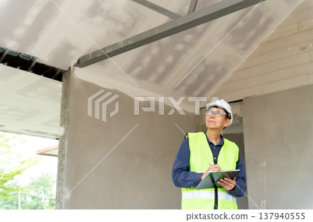 Construction supervisors are reviewing and writing checklists Construction supervisors are reviewing and writing checklists 137940555