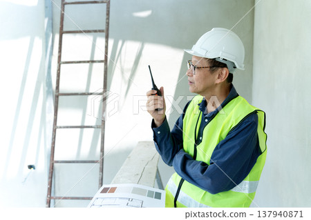 construction site manager is using radio to order construction construction site manager is using radio to order construction 137940871