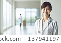 Smiling Female Doctor | A Trustworthy Portrait of a Female Doctor in a White Coat and Stethoscope 137941197