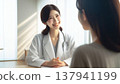 Smiling Female Doctor | A Trustworthy Portrait of a Female Doctor in a White Coat and Stethoscope 137941199
