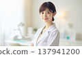 Smiling Female Doctor | A Trustworthy Portrait of a Female Doctor in a White Coat and Stethoscope 137941200