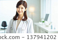 Smiling Female Doctor | A Trustworthy Portrait of a Female Doctor in a White Coat and Stethoscope 137941202