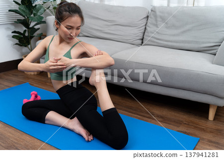 young woman do yoga at home in living room on the yoga mat young woman do yoga at home in living room on the yoga mat 137941281