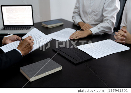 Business brainstorming meeting Executives reviewing a draft document 137941291