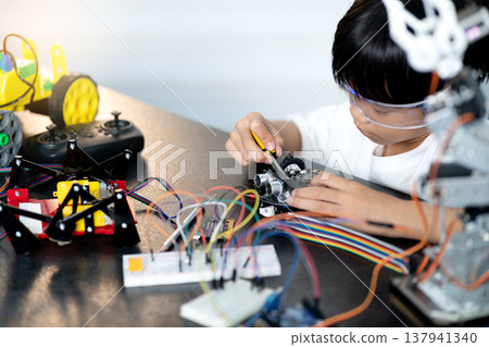 Asian boy is paying attention and adding and improving Asian boy is paying attention and adding and improving 137941340