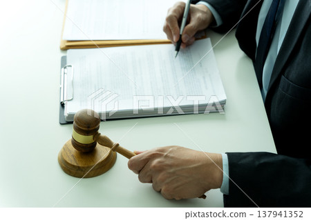 lawyer sitting and holding gavel hands preparing to smash on pedestal symbolizing 137941352