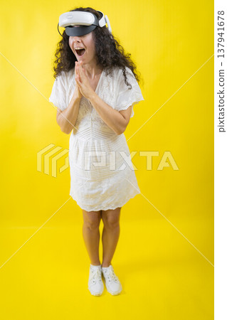 Woman experiencing virtual reality world with surprise Woman experiencing virtual reality world with surprise 137941678