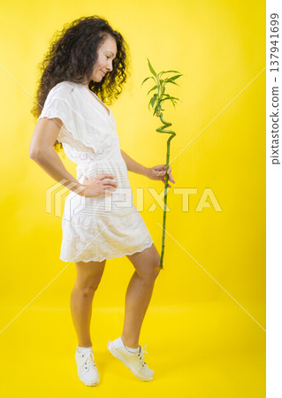 Woman holding lucky bamboo representing growth and happiness Woman holding lucky bamboo representing growth and happiness 137941699