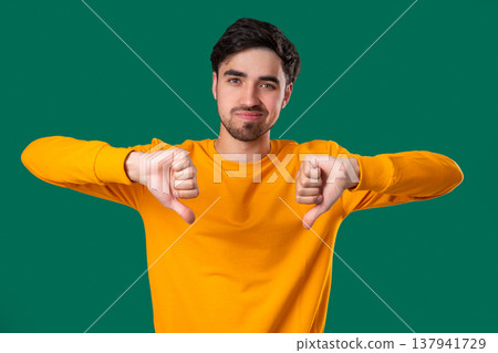 Portrait of unhappy man condemns with sign of dislike. Young millennial guy 137941729