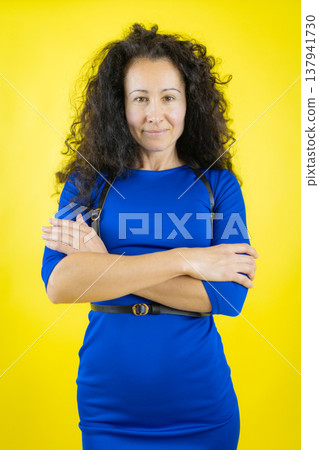 Confident woman with curly hair crossing arms 137941730