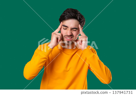 20S Aged Man Having Headache, Touching Temples, Suffering On yellow Background. 20S Aged Man Having Headache, Touching Temples, Suffering On yellow Background. 137941731