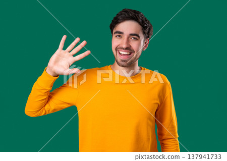 Friendly 20S Aged Man Waving Hand - Hello, Hi, Salute, Chao. Greetings On Green 137941733