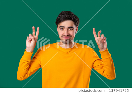 Skeptic young man With Hands Two Fingers Air Quotes On green, Sarcasm,Cynicism 137941735