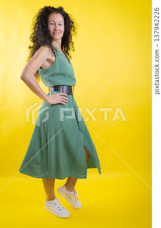 Mid-adult woman posing, happy and confident, in green dress Mid-adult woman posing, happy and confident, in green dress 137942226