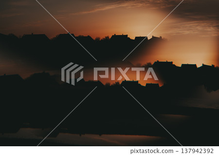 Abstract double exposure of a village silhouette at sunset. Surreal landscape with house reflections in water, dark moody atmosphere, Abstract double exposure of a village silhouette at sunset. Surreal landscape with house reflections in water, dark moody atmosphere, 137942392