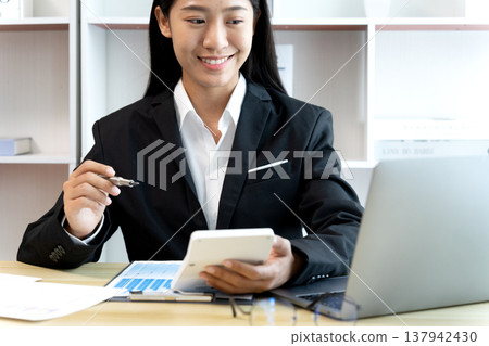 businesswoman Looking at laptop screen and hand pressing calculator businesswoman Looking at laptop screen and hand pressing calculator 137942430