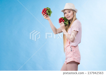 Young woman holding radish Young woman holding radish 137942563