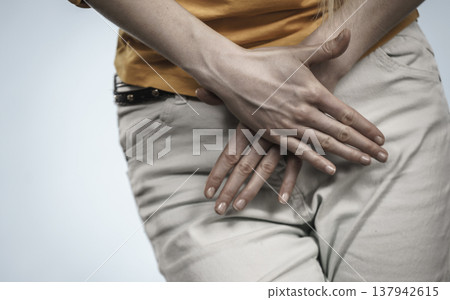 Woman with hands holding her crotch Woman with hands holding her crotch 137942615