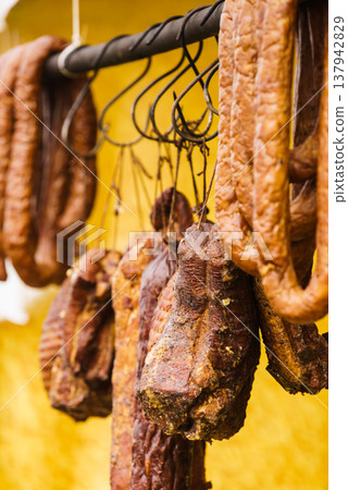 Smoked sausages meat hanging in smokehouse 137942829