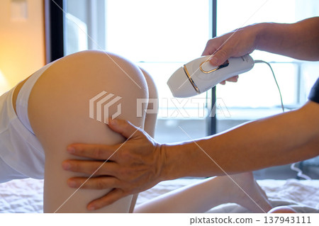 一名女子在伴侶（男友、丈夫）的幫助下，四肢著地使用家用除毛儀進行 VIO 除毛。 137943111