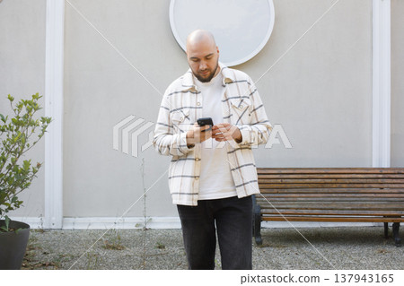 Portrait of Man Using Smartphone Outdoors. City Connecting with People Online 137943165