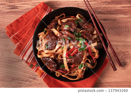 Udon noodles with beef in Mongolian style, with green onions and vegetables, homemade, on a wooden table, Udon noodles with beef in Mongolian style, with green onions and vegetables, homemade, on a wooden table, 137943260