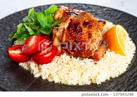 Grilled chicken served with couscous with fresh vegetables and herbs on a black platter, Greek cuisine, homemade, Grilled chicken served with couscous with fresh vegetables and herbs on a black platter, Greek cuisine, homemade, 137943296