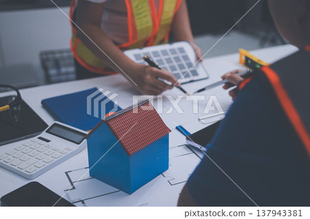 engineer and an architect reviewing blueprints and construction plans together at a bustling construction site engineer and an architect reviewing blueprints and construction plans together at a bustling construction site 137943381